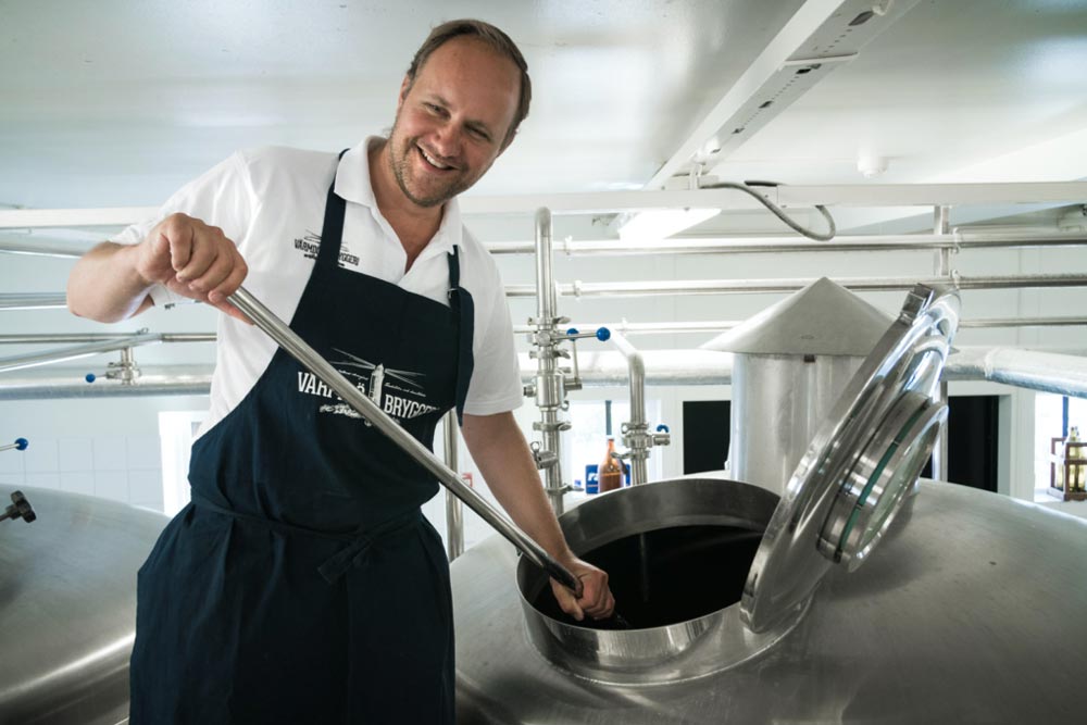 Man som rör om dryck i bryggeriet